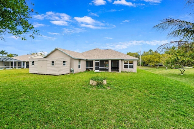 rear view of property with a sunroom and a lawn