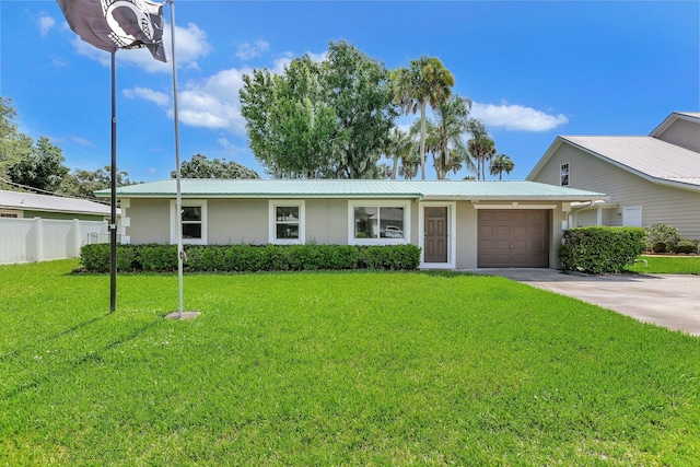 ranch-style home featuring an attached garage, metal roof, fence, driveway, and a front lawn