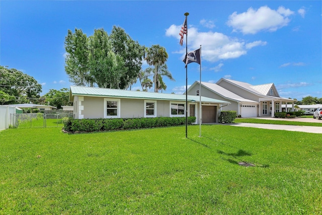 ranch-style house featuring metal roof, fence, a garage, driveway, and a front lawn