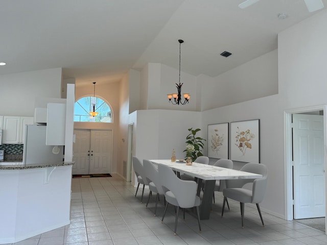 3190 SE Carrick Green Ct, Port Saint Lucie, FL 34952 - dining space featuring high vaulted ceiling, a chandelier, light tile patterned floors, and baseboards