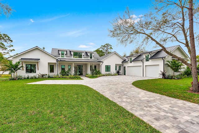 modern farmhouse featuring metal roof, decorative driveway, and a standing seam roof