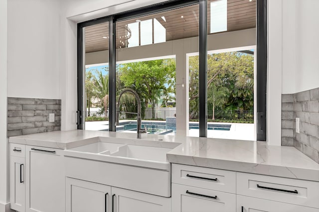 kitchen featuring tasteful backsplash, a wealth of natural light, and a sink