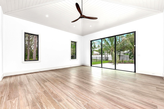 spare room featuring light wood finished floors, wood ceiling, vaulted ceiling, ceiling fan, and baseboards