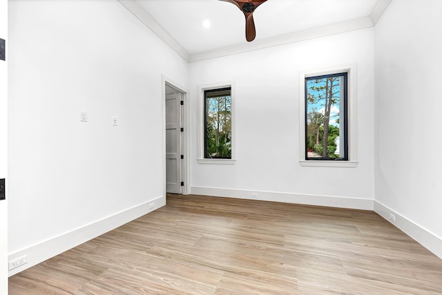 unfurnished room featuring baseboards, light wood-type flooring, and crown molding