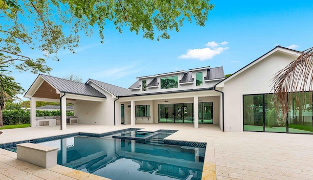 rear view of property featuring ceiling fan, a patio, metal roof, stucco siding, and a standing seam roof