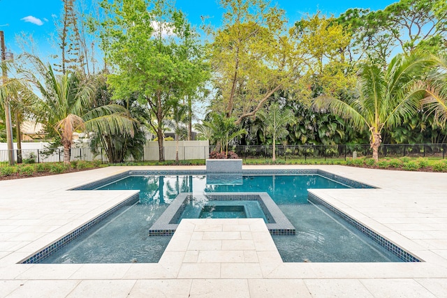 view of pool featuring a pool with connected hot tub, fence, and a patio