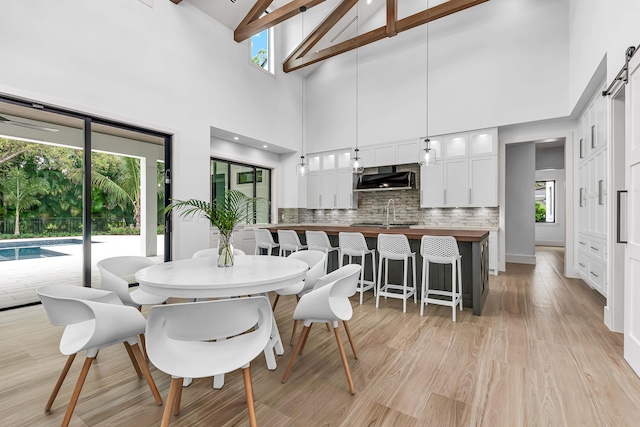 dining room with vaulted ceiling, light wood finished floors, and a wealth of natural light