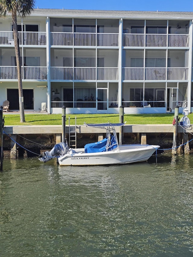 view of dock featuring a water view and a yard