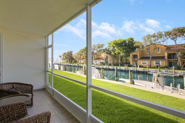 sunroom / solarium with a water view and a residential view