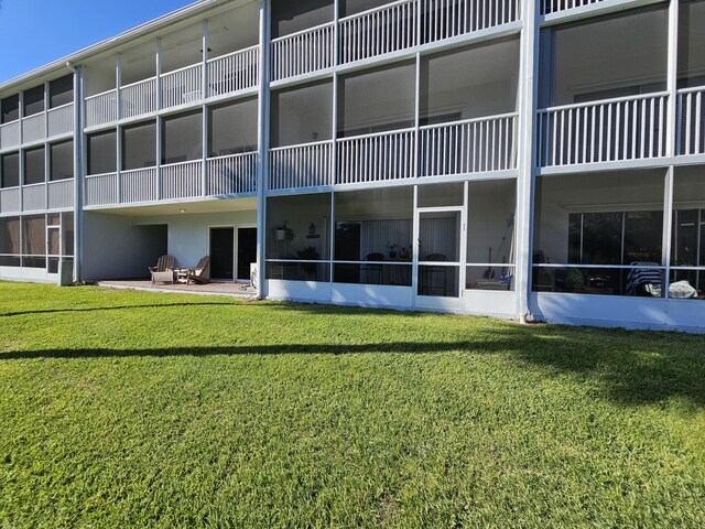 rear view of house featuring a lawn