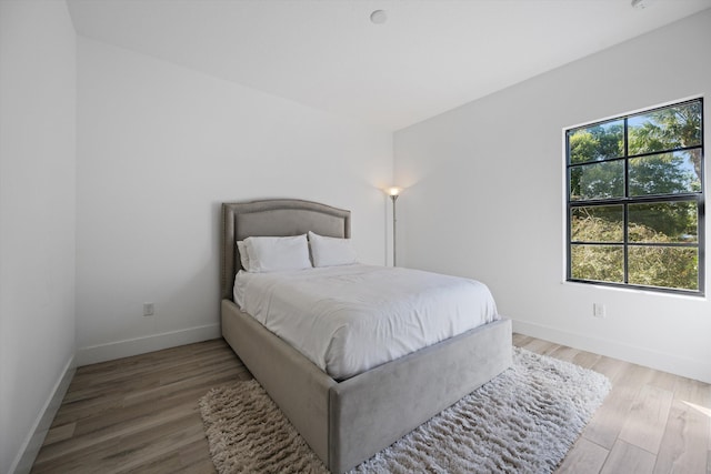 bedroom with baseboards and light wood finished floors