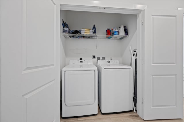 washroom featuring laundry area, washer and clothes dryer, and light wood-style floors