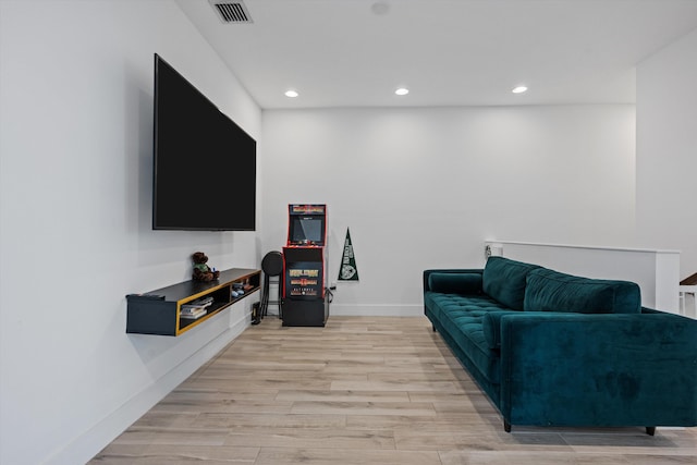 living area featuring light wood-style floors, recessed lighting, visible vents, and baseboards