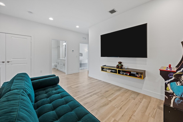 living area with recessed lighting, visible vents, baseboards, and wood finished floors