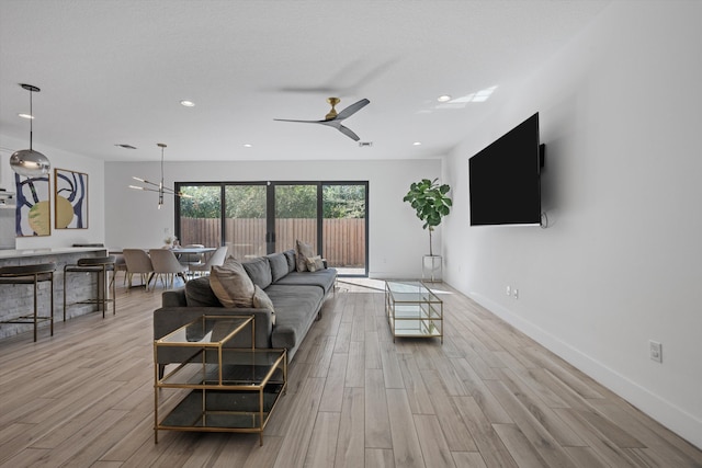 living area with recessed lighting, ceiling fan, baseboards, and wood finished floors