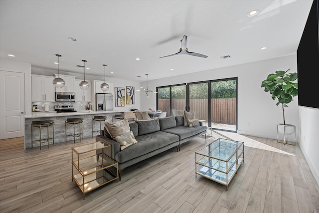 living area featuring ceiling fan, light wood finished floors, visible vents, and recessed lighting