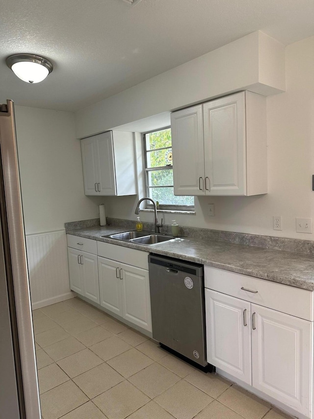 kitchen with stainless steel appliances, white cabinetry, and a sink