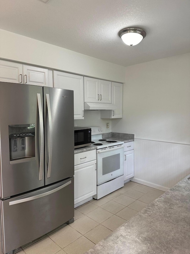 kitchen featuring a wainscoted wall, stainless steel refrigerator with ice dispenser, white electric range oven, white cabinetry, and under cabinet range hood