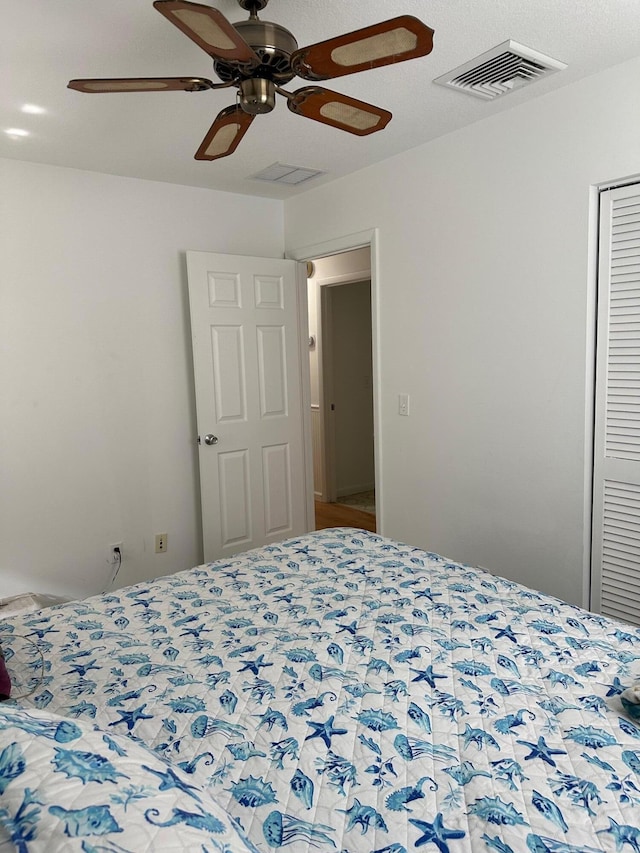 bedroom with ceiling fan, visible vents, and a closet