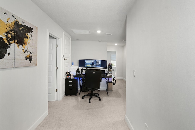 carpeted office with a textured ceiling and baseboards