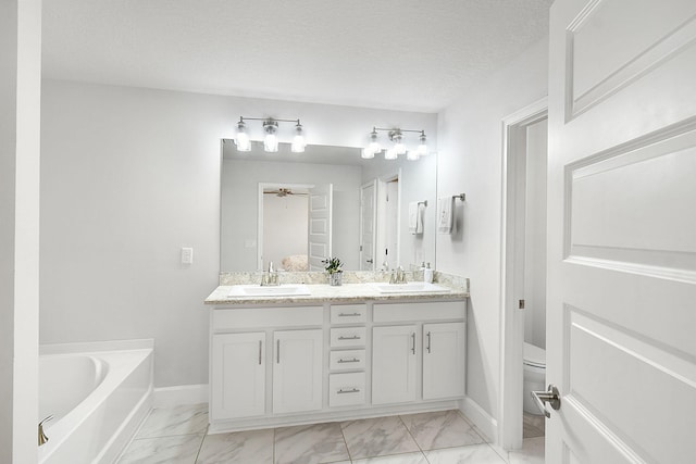 full bathroom with marble finish floor, a sink, a textured ceiling, and toilet