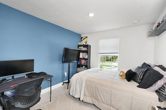 bedroom featuring a textured ceiling, baseboards, and carpet flooring