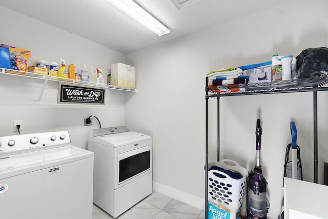 laundry room with marble finish floor, laundry area, washing machine and clothes dryer, and baseboards