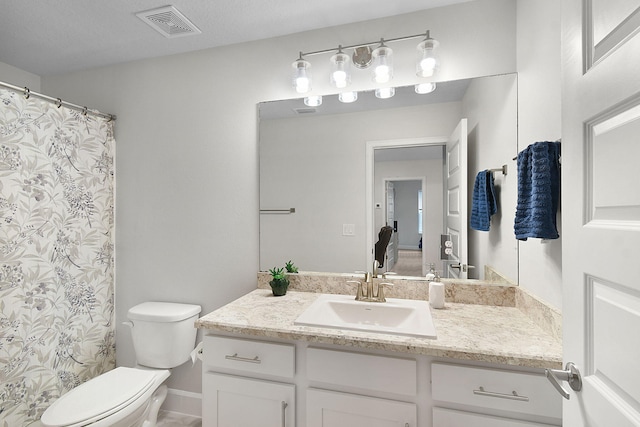 bathroom with toilet, vanity, visible vents, and a shower with curtain