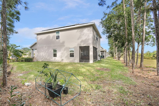 rear view of house with a lawn and a vegetable garden