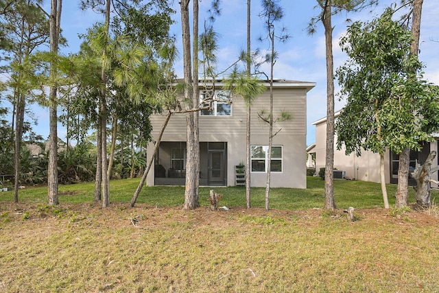 back of house with a sunroom and a yard