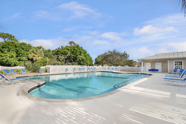 pool with a patio area and fence