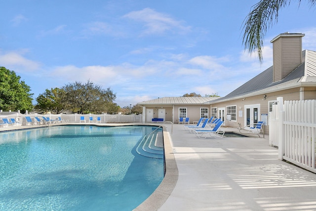 pool with fence, a patio, and french doors