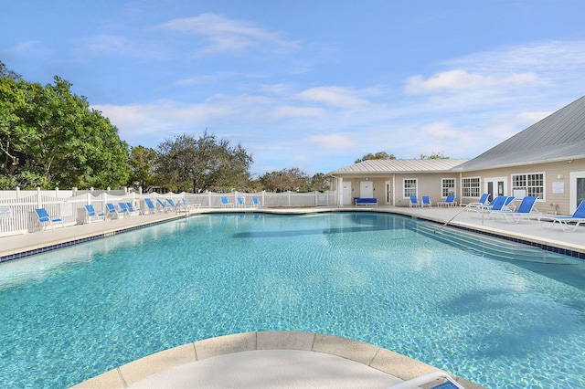 community pool with a patio area and fence