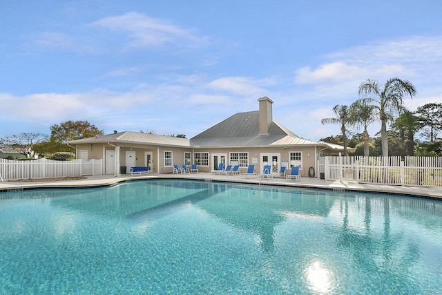 community pool with a patio area and fence