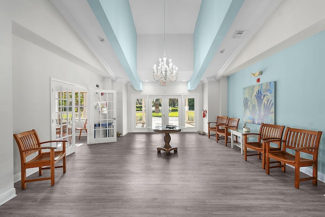 sitting room featuring french doors, wood finished floors, a high ceiling, and baseboards