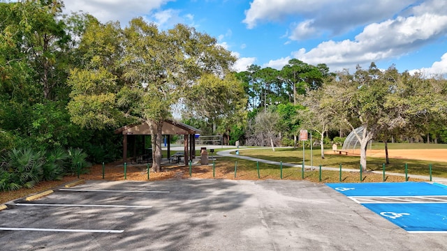 uncovered parking lot with community basketball court and fence