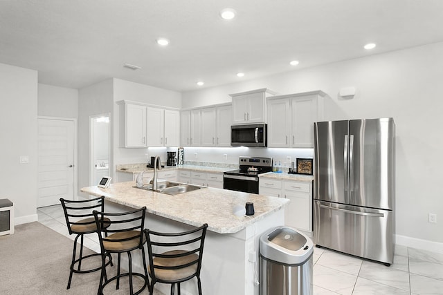 kitchen with stainless steel appliances, recessed lighting, visible vents, a sink, and a kitchen breakfast bar