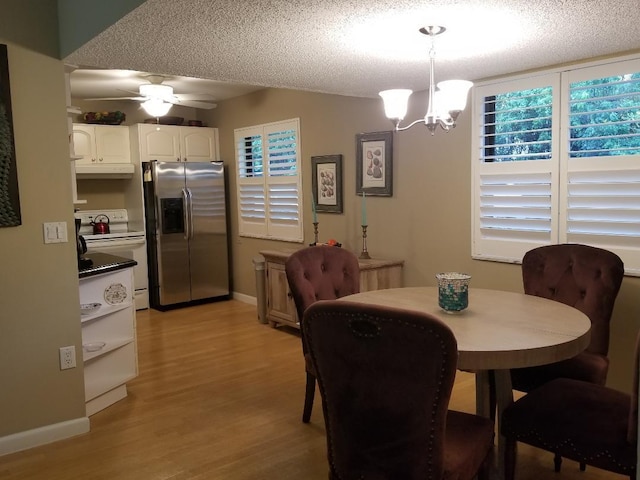 2424 N Federal Hwy Unit 106, Boynton Beach, FL 33435 - dining room featuring light wood finished floors, baseboards, a textured ceiling, and ceiling fan with notable chandelier