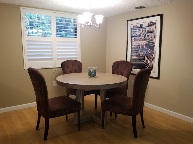 2424 N Federal Hwy Unit 106, Boynton Beach, FL 33435 - dining space with baseboards, a notable chandelier, and light wood finished floors