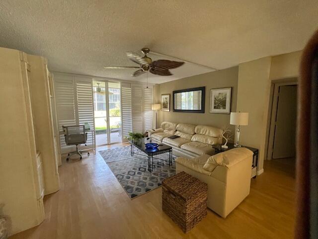 2424 N Federal Hwy Unit 106, Boynton Beach, FL 33435 - living room featuring ceiling fan, a textured ceiling, and light wood-type flooring