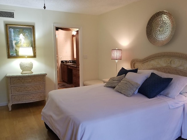 2424 N Federal Hwy Unit 106, Boynton Beach, FL 33435 - bedroom featuring baseboards, wood finished floors, and visible vents