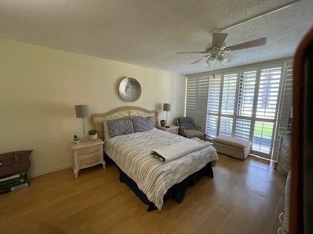 2424 N Federal Hwy Unit 106, Boynton Beach, FL 33435 - bedroom featuring baseboards, wood finished floors, a textured ceiling, and ceiling fan