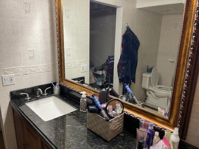 2424 N Federal Hwy Unit 106, Boynton Beach, FL 33435 - bathroom featuring tile walls, toilet, and vanity