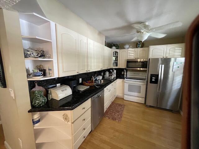 2424 N Federal Hwy Unit 106, Boynton Beach, FL 33435 - kitchen featuring a sink, light wood-style floors, ceiling fan, open shelves, and appliances with stainless steel finishes