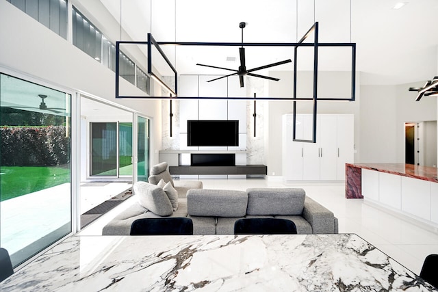 living area featuring a ceiling fan and a towering ceiling