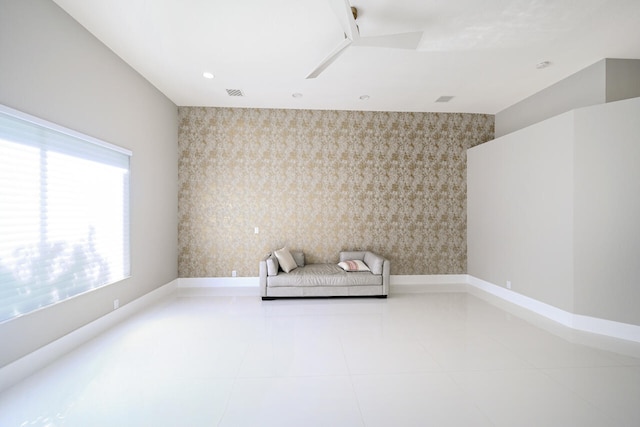 unfurnished room featuring baseboards, an accent wall, tile patterned floors, and wallpapered walls