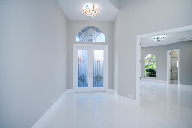 tiled entrance foyer featuring french doors and baseboards