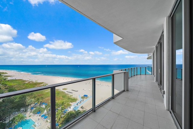 balcony with a water view and a view of the beach