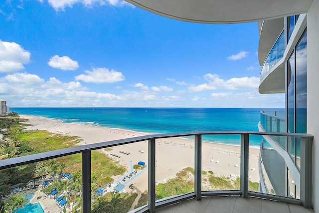 balcony featuring a water view and a view of the beach