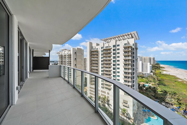 balcony with a water view, a view of city, and a beach view